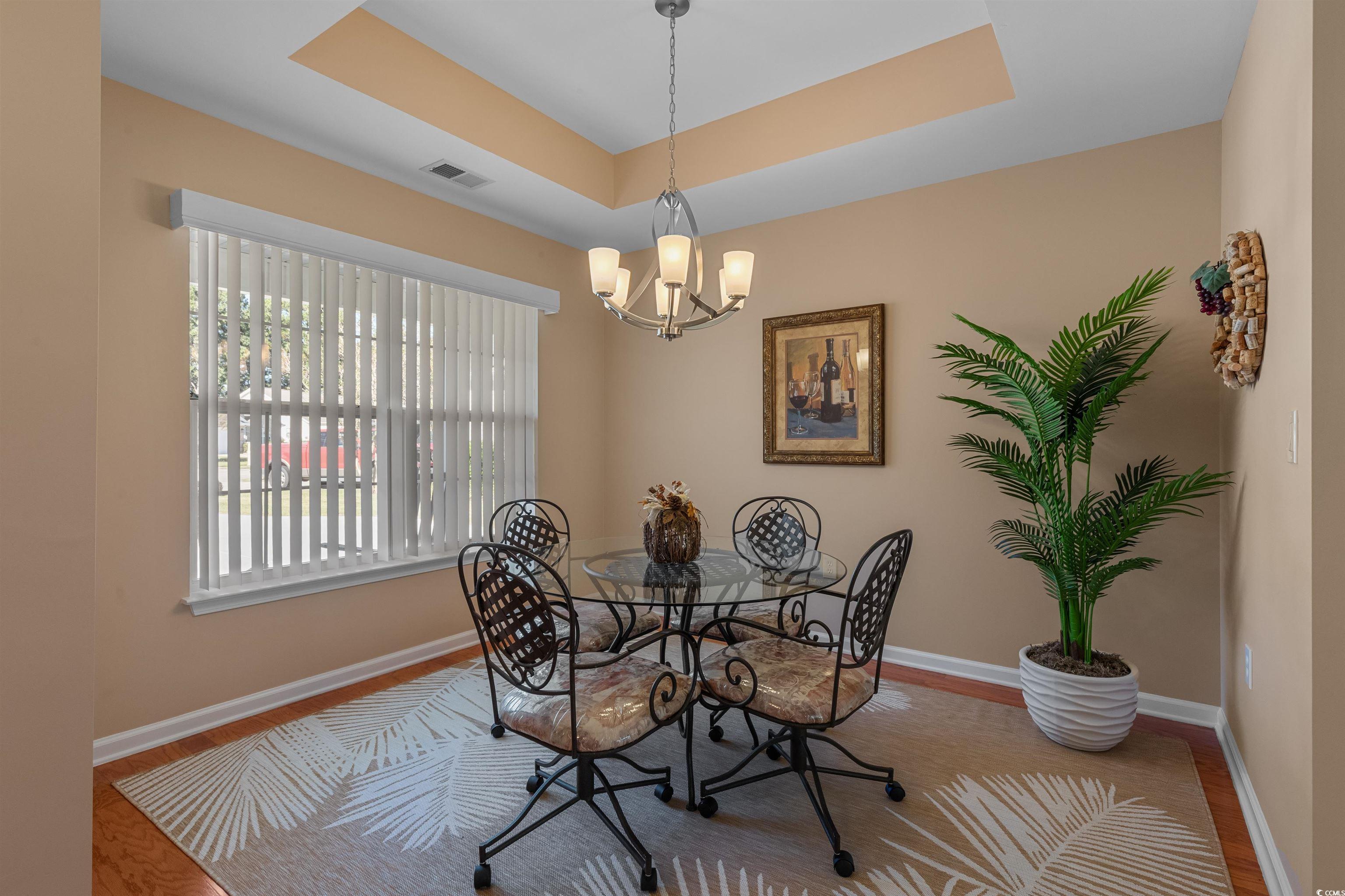3505 Arrowhead Boulevard Myrtle Beach, SC 29579 - Photo 4 of 40 Dining room featuring a raised ceiling, a chandelier, and wood finished floors