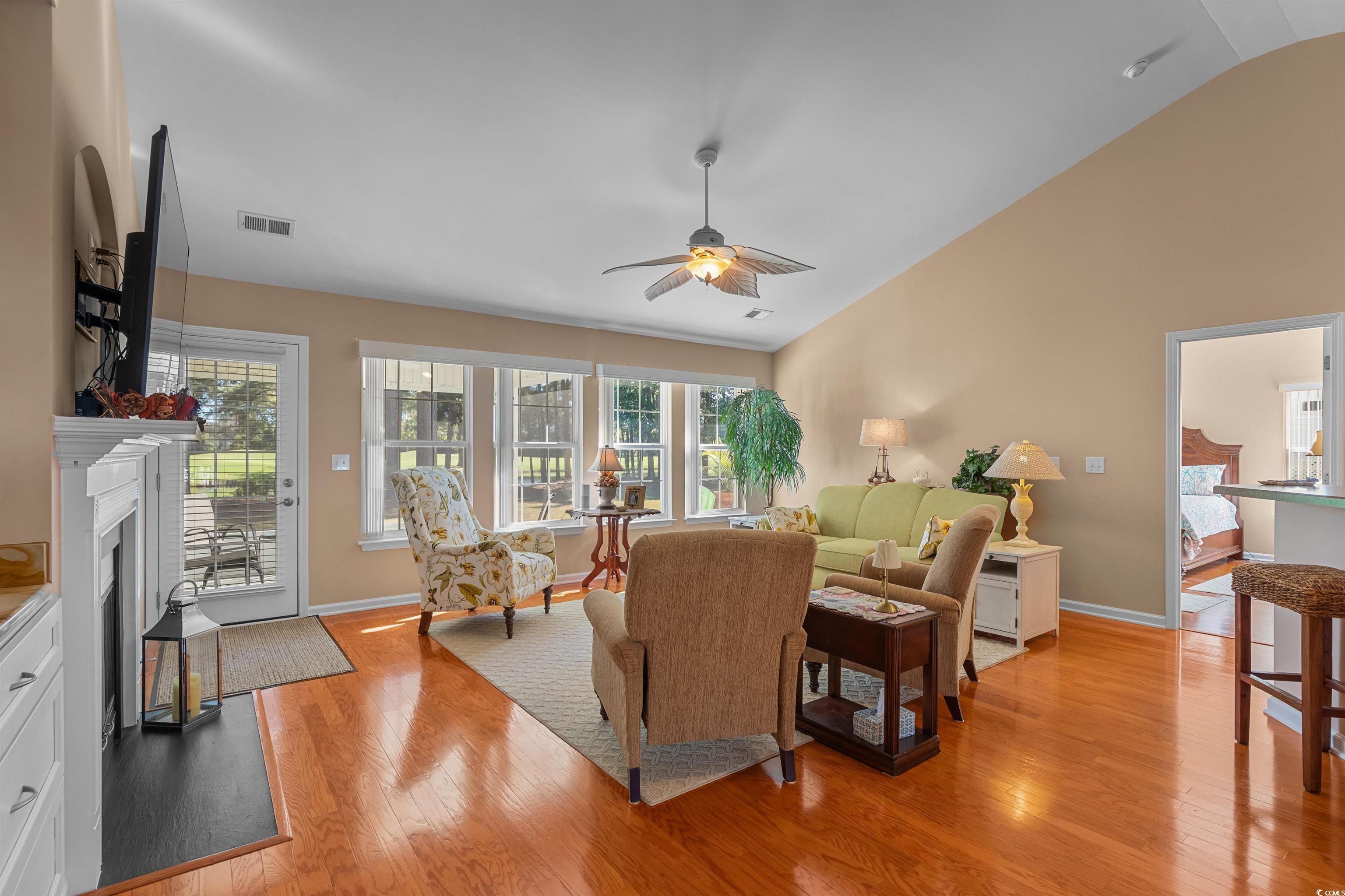 3505 Arrowhead Boulevard Myrtle Beach, SC 29579 - Photo 6 of 40 Living room featuring light wood-style flooring, a fireplace with flush hearth, a ceiling fan, and high vaulted ceiling