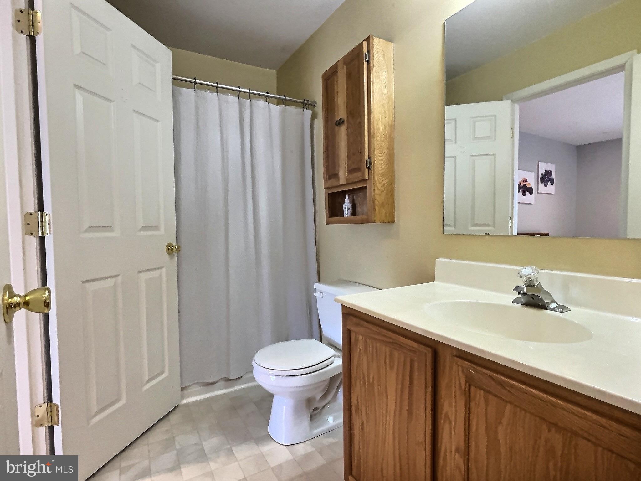 42 Highland Circle Newark, DE 19713 - Photo 14 of 19 a bathroom with a sink a toilet and shower curtain