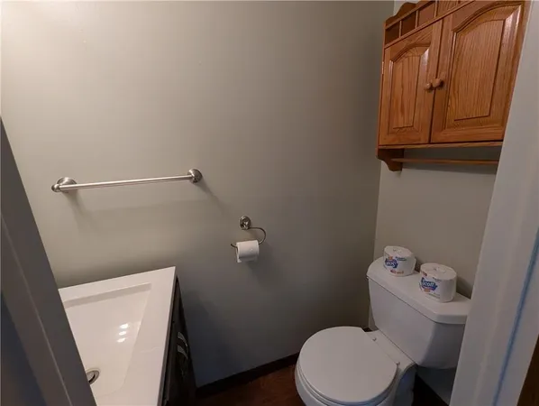 a white toilet sitting next to a sink and vanity