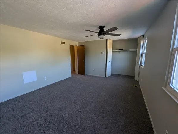 a view of a big room with a ceiling fan and a window