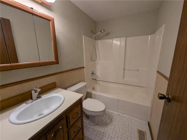 a bathroom with a granite countertop sink toilet a mirror and shower