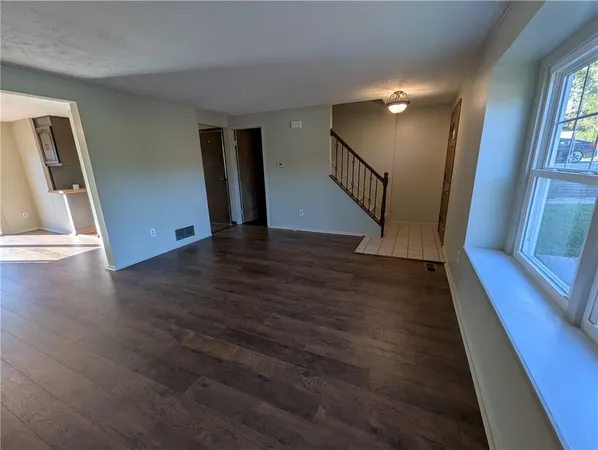a view of a hallway with wooden floor and stairs