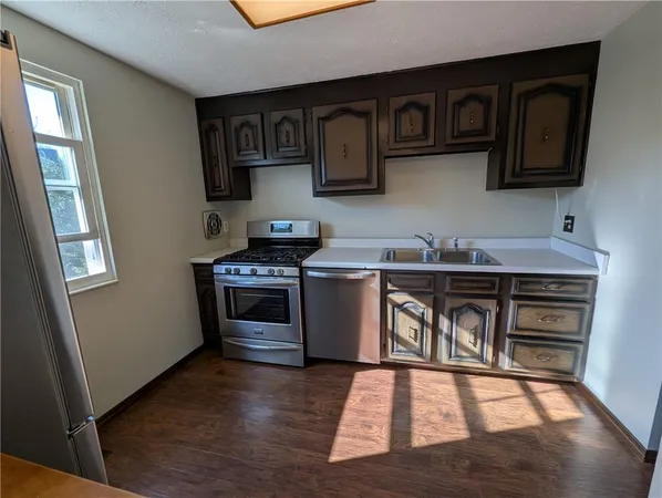 a kitchen with stainless steel appliances granite countertop a stove a sink and a microwave