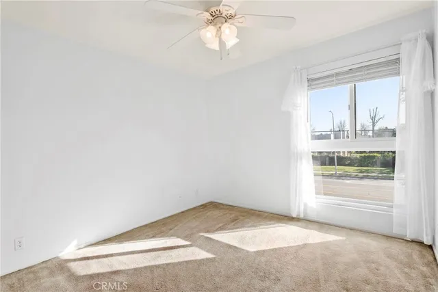 an empty room with a window and a ceiling fan