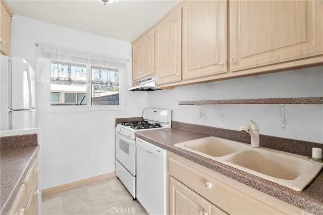 a kitchen with stainless steel appliances granite countertop a sink and a white cabinets