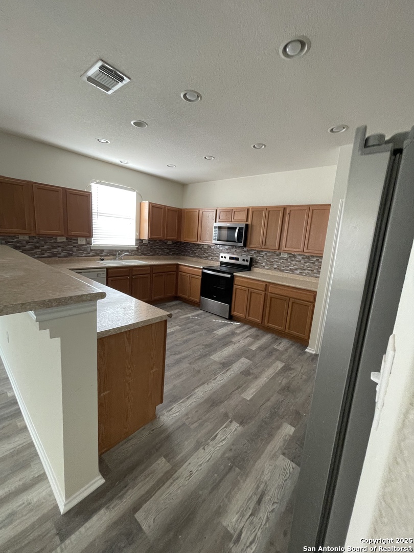 11111 Denae Drive Live Oak, TX 78233 - Photo 13 of 43 a view of kitchen with kitchen island a sink wooden floor and living room