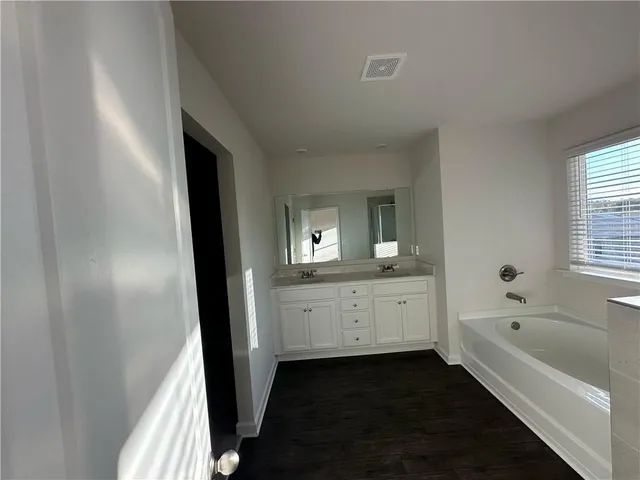 a bathroom with a bathtub sink and mirror