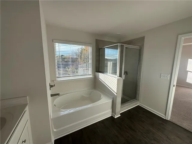 a white bath tub sitting in a bathroom next to a window