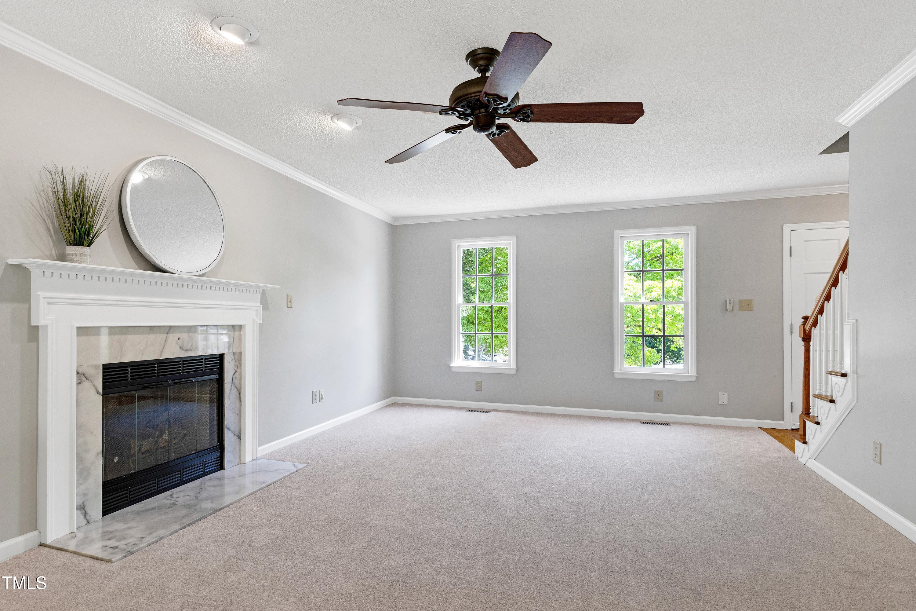 300 Silvercliff Trail Cary, NC 27513 - Photo 4 of 27 a view of a livingroom with a fireplace a ceiling fan and windows