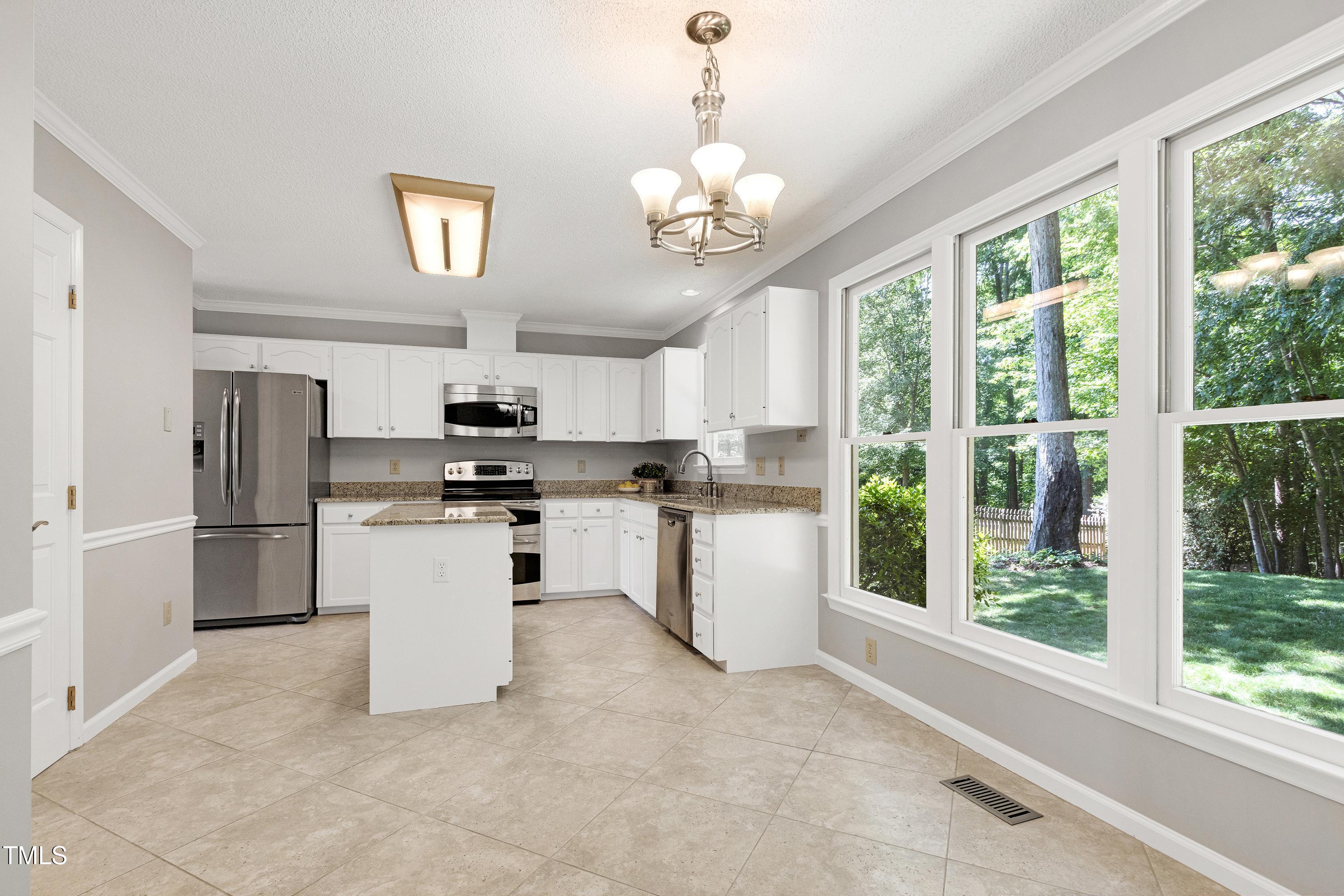 300 Silvercliff Trail Cary, NC 27513 - Photo 5 of 27 a kitchen with stainless steel appliances granite countertop a refrigerator a sink dishwasher a oven with a dining table and chairs