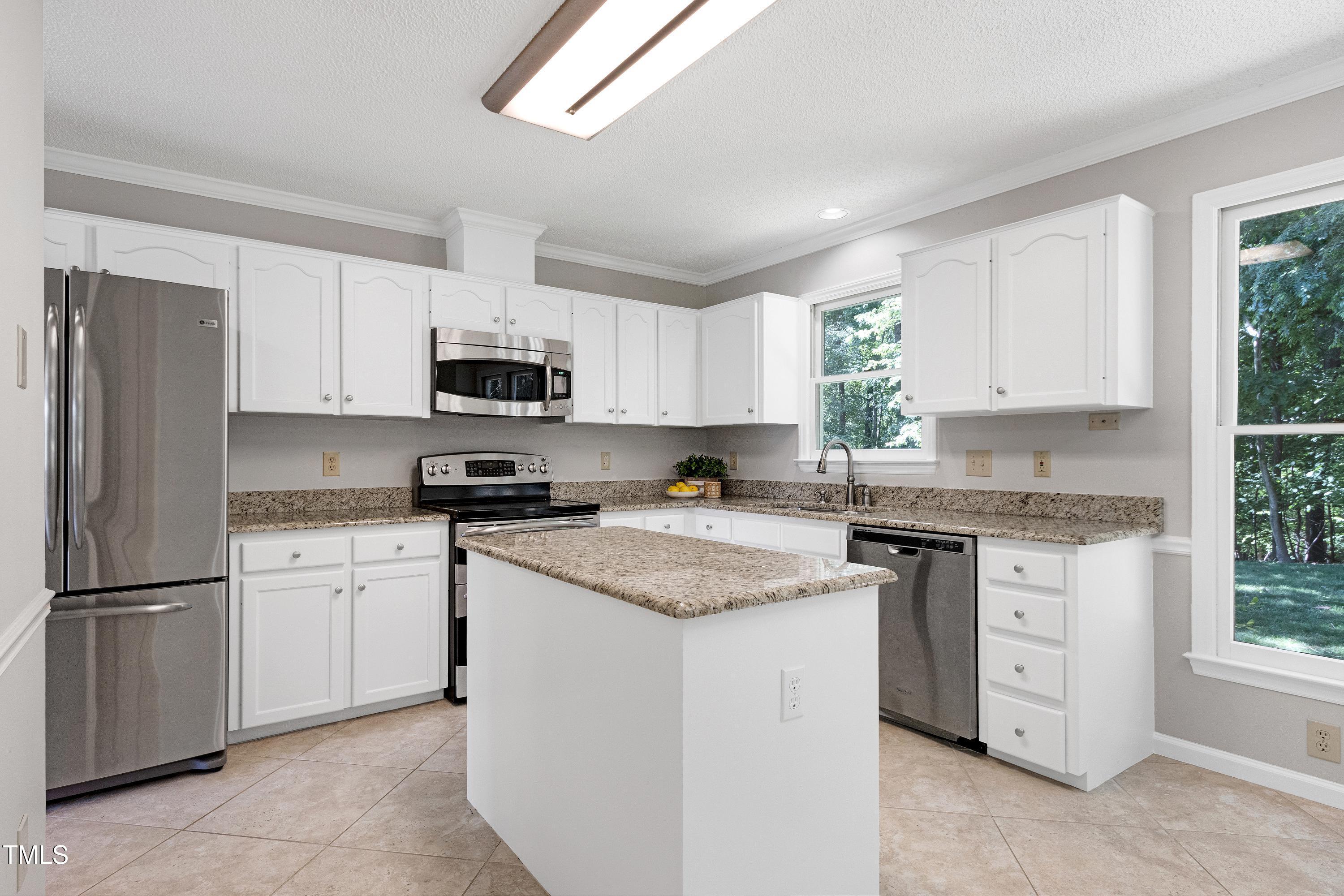 300 Silvercliff Trail Cary, NC 27513 - Photo 6 of 27 a kitchen with granite countertop white cabinets and white appliances