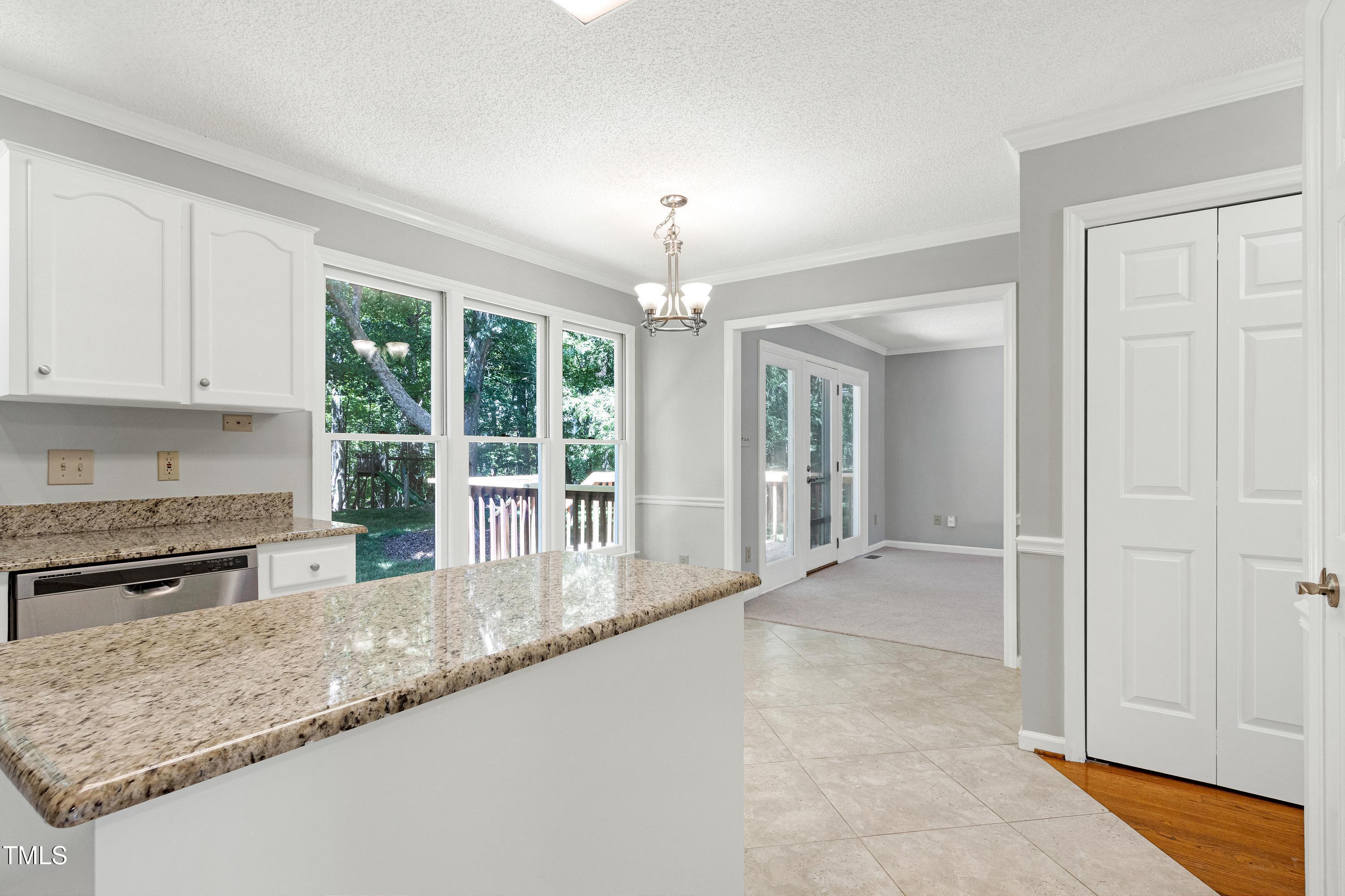 300 Silvercliff Trail Cary, NC 27513 - Photo 7 of 27 a kitchen with granite countertop a sink and white cabinets