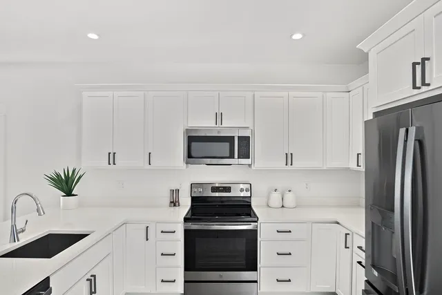 a kitchen with white cabinets and stainless steel appliances