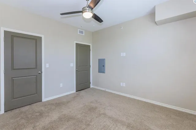 an empty room with wooden floor and chandelier fan