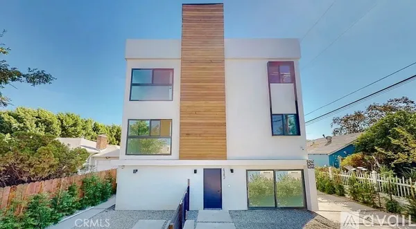 a view of a house with a balcony and trees