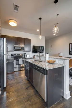 a kitchen with stainless steel appliances granite countertop a sink stove and refrigerator