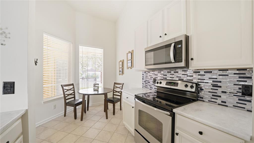 705 Augusta Circle, Unit 705 St. Augustine, FL 32086 - Photo 14 of 53 a kitchen with stainless steel appliances a stove a sink and white cabinets