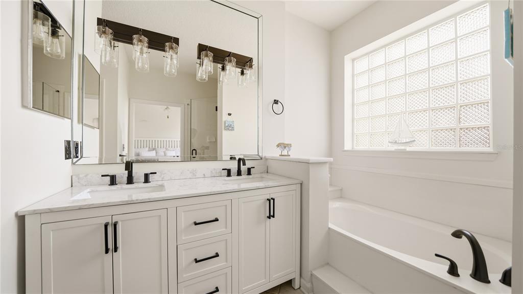 705 Augusta Circle, Unit 705 St. Augustine, FL 32086 - Photo 22 of 53 a bathroom with a double vanity sink and mirror with bathtub