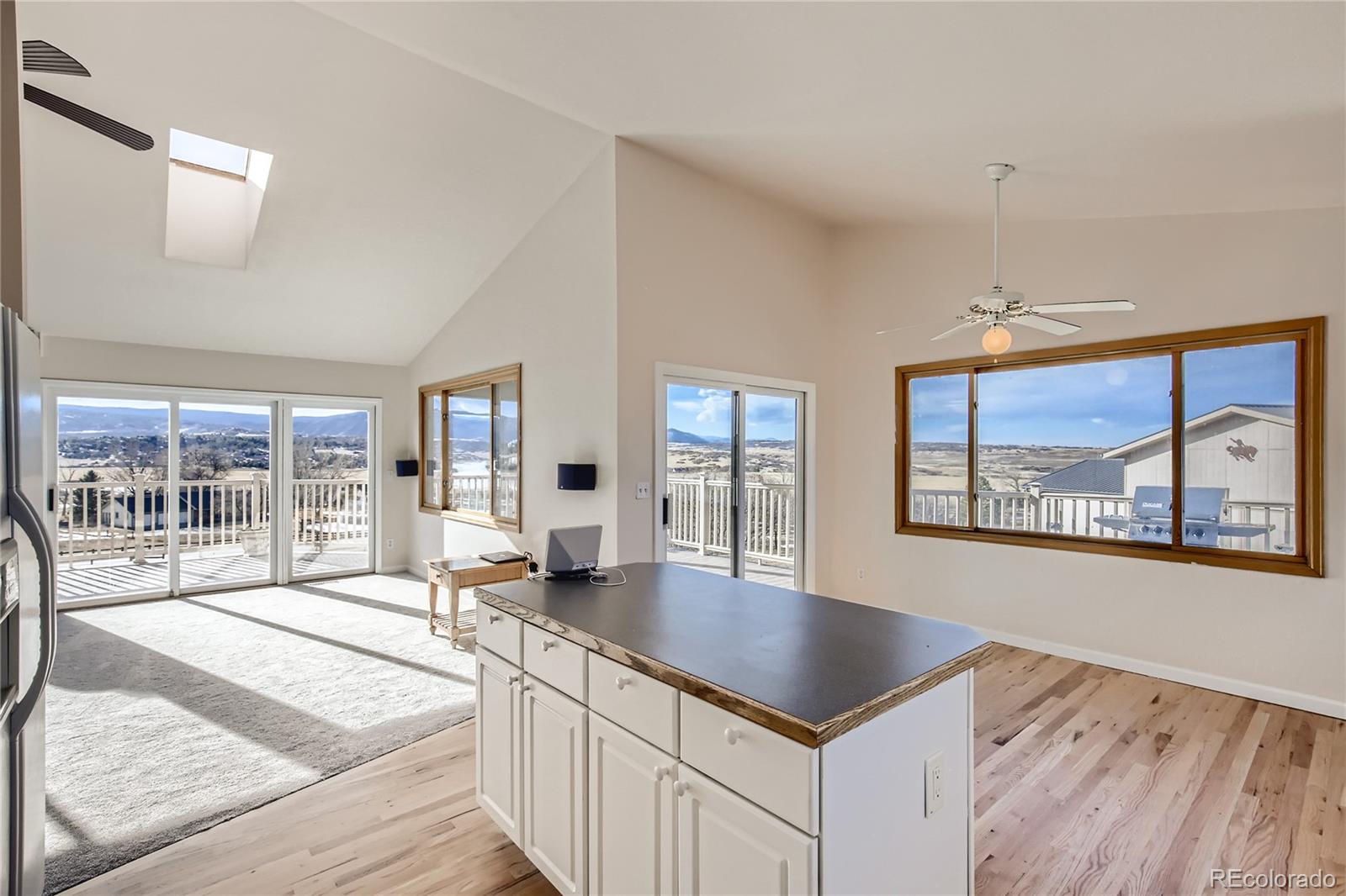 3961 Bear Canyon Circle Sedalia, CO 80135 - Photo 11 of 40 a open kitchen with stainless steel appliances granite countertop a stove top oven a sink dishwasher and white cabinets with wooden floor