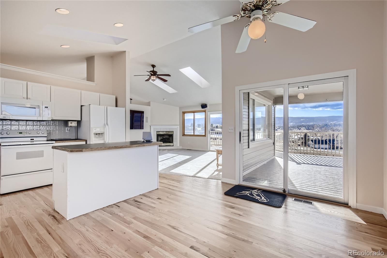 3961 Bear Canyon Circle Sedalia, CO 80135 - Photo 13 of 40 a kitchen with granite countertop a refrigerator and white cabinets