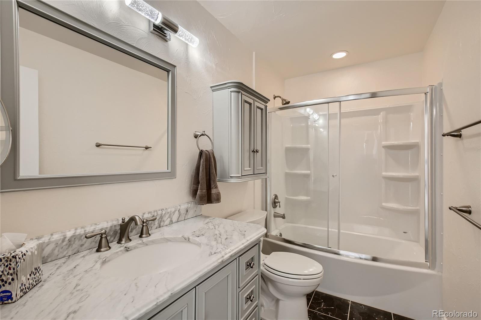 3961 Bear Canyon Circle Sedalia, CO 80135 - Photo 20 of 40 a bathroom with a granite countertop sink toilet and shower