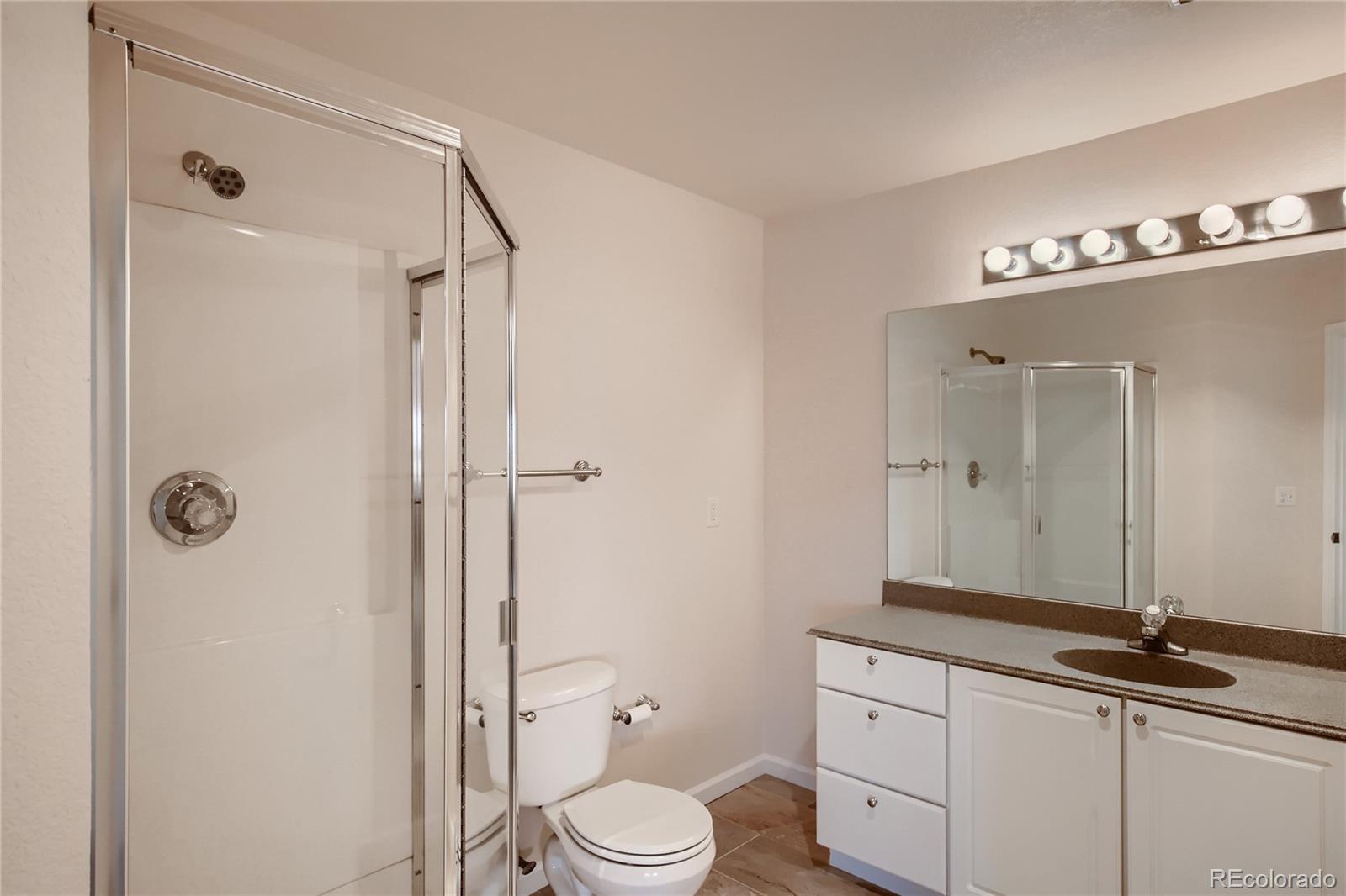 3961 Bear Canyon Circle Sedalia, CO 80135 - Photo 24 of 40 a bathroom with a granite countertop sink toilet mirror and shower