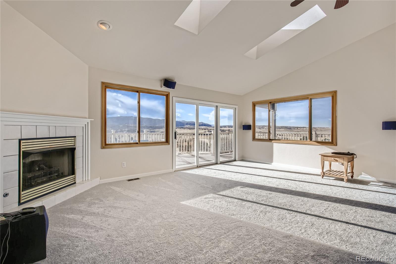 3961 Bear Canyon Circle Sedalia, CO 80135 - Photo 5 of 40 a living room with a large window and a fireplace