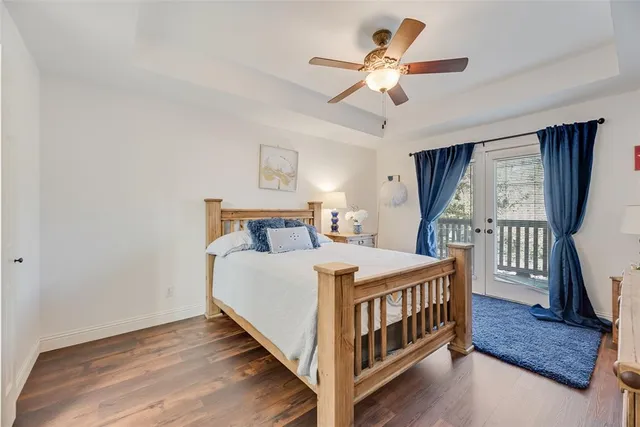 a bedroom with a bed a window and wooden floor