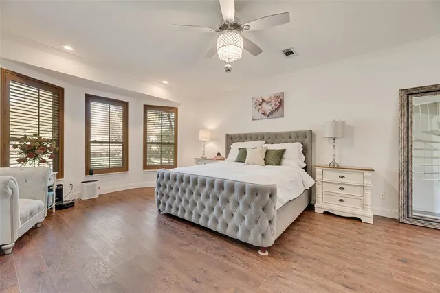 a bedroom with a large bed and a chandelier