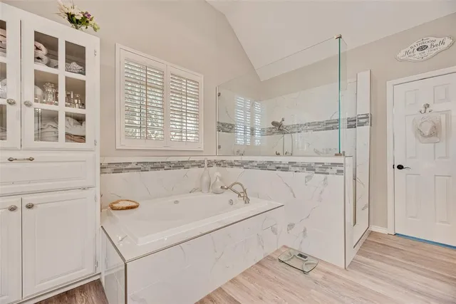 a bathroom with a tub a sink and a window