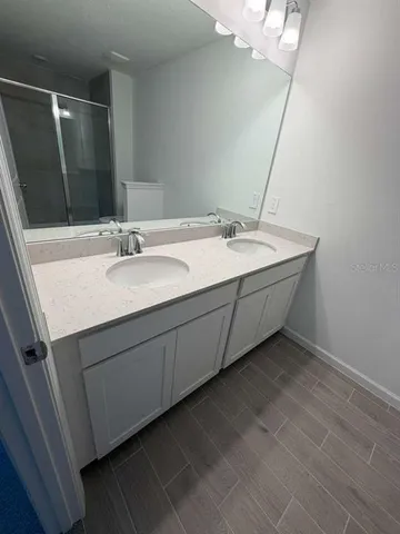 a bathroom with a double vanity sink and a mirror