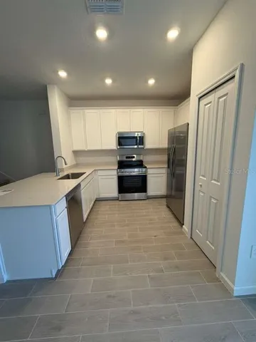 a kitchen with refrigerator and cabinets