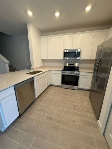 a kitchen with stainless steel appliances granite countertop a sink counter space cabinets and a stove