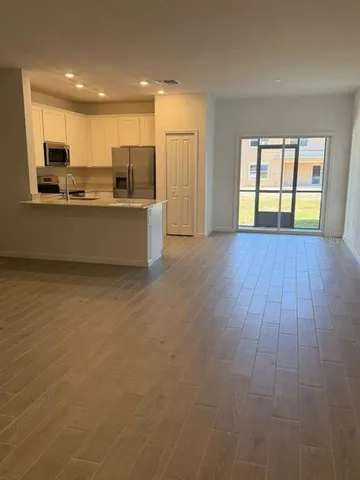 a view of kitchen with wooden floor and electronic appliances