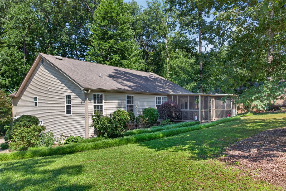 151 Towne Creek Trail Anderson, SC 29621 - Photo 48 of 49 A private, secluded home, enveloped by mature trees, features a comfortable screened porch overlooking a sloped yard.