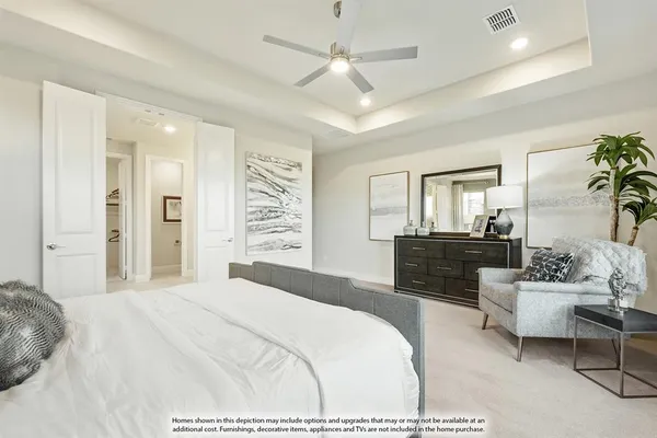 a bedroom with a large bed couch and windows