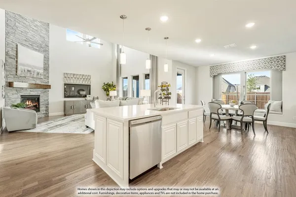 a large white dining hall with stainless steel appliances granite countertop a stove oven a flat screen tv and a fireplace