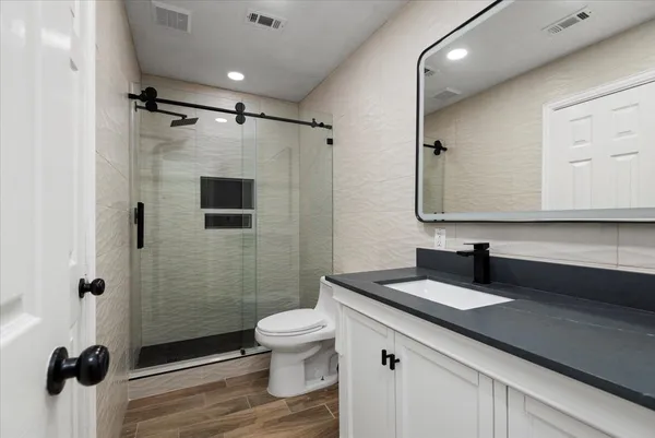 a bathroom with a granite countertop sink toilet and shower