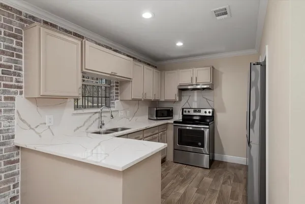 a kitchen with stainless steel appliances granite countertop a sink stove and refrigerator