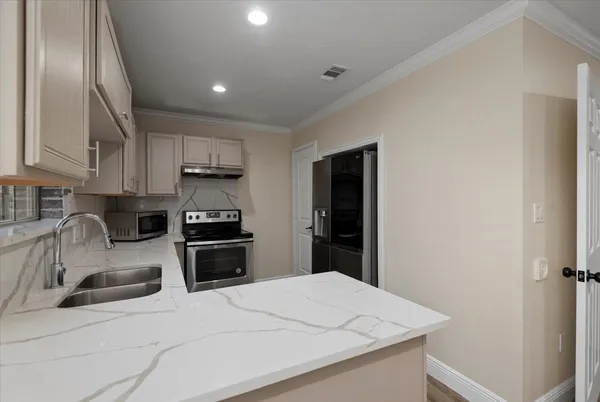a kitchen with granite countertop white cabinets and stainless steel appliances