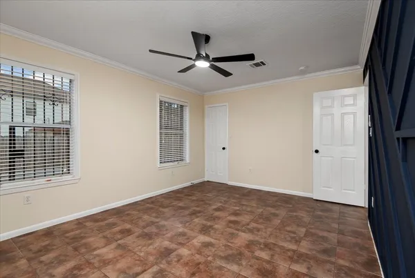 a view of empty room with window and ceiling fan