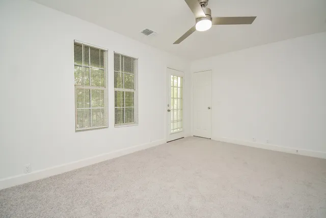 an empty room with chandelier fan