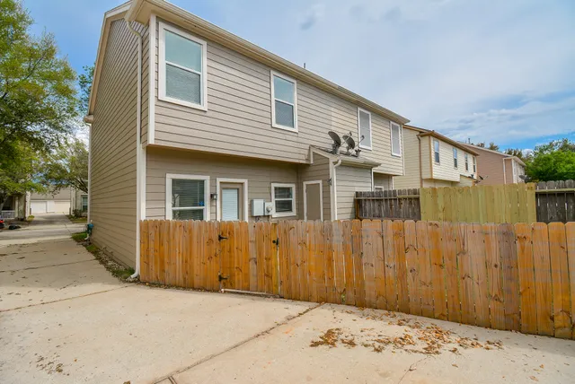a view of a house with a wooden fence