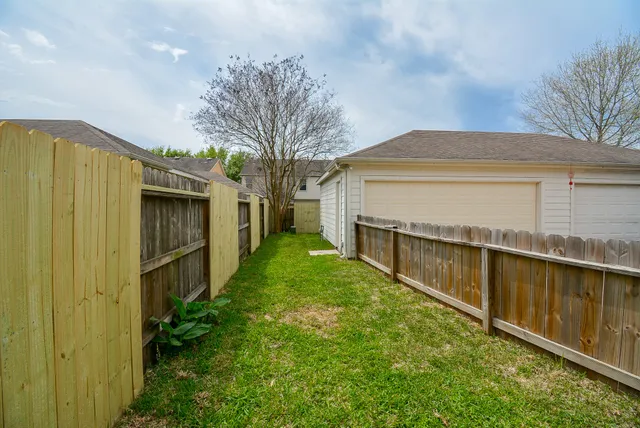 a view of house with backyard and trees