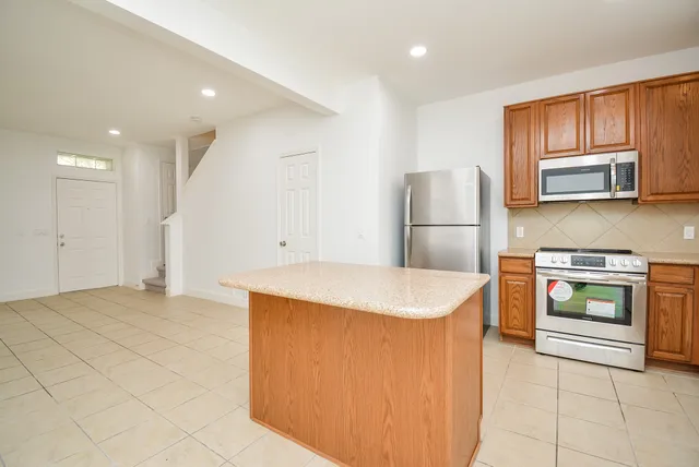 a kitchen with stainless steel appliances granite countertop a stove a microwave and a refrigerator