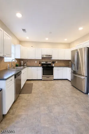 a large kitchen with stainless steel appliances lots of counter space and a sink