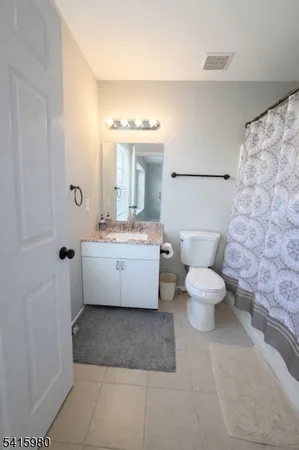 a bathroom with a double vanity sink mirror and toilet