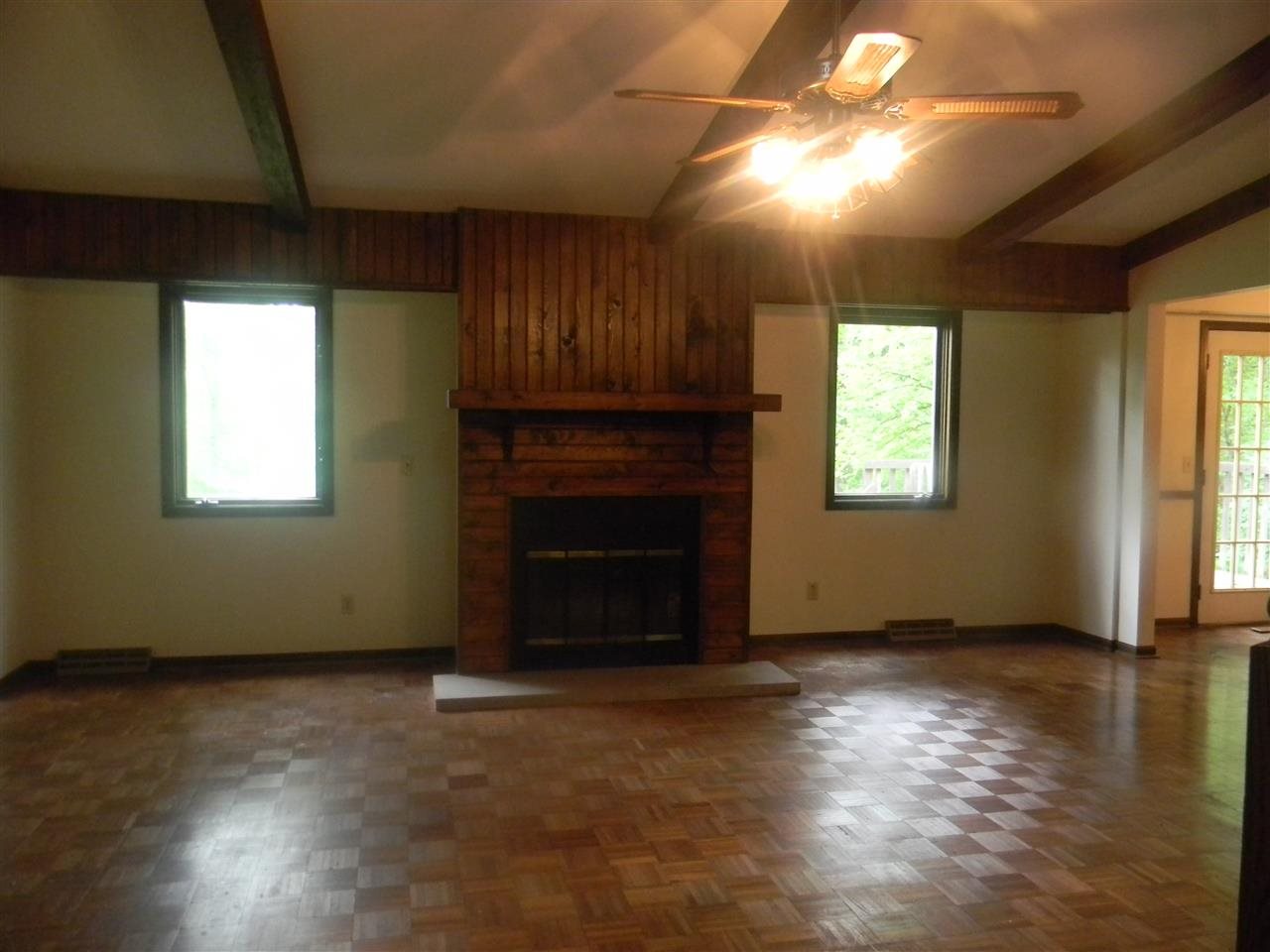 2150 Lake Summerset Road Davis, IL 61019 - Photo 11 of 18 an empty room with windows a fireplace and wooden floor