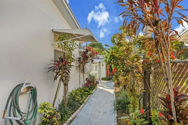a front view of a house with a lot of flower plants